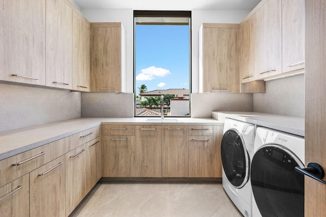 laundry room with cabinets, sink, and washer and dryer