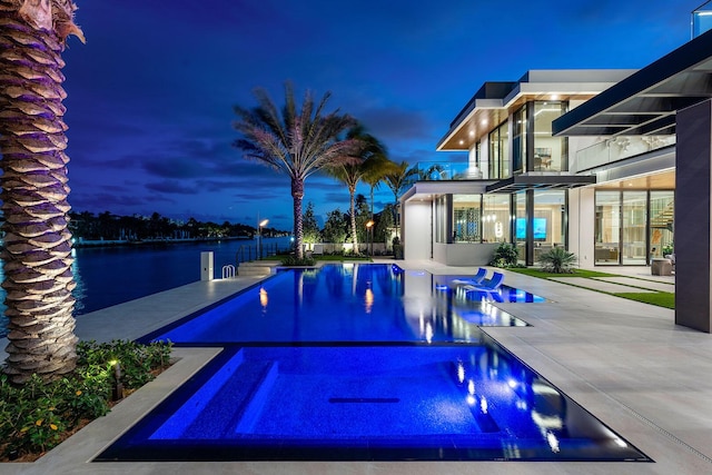 1520 Royal Palm Way, Boca Raton, FL 33432 - pool at night featuring a patio and a pool with connected hot tub