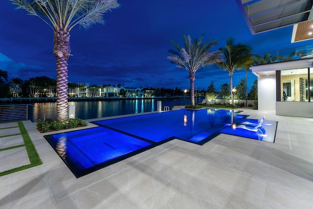1520 Royal Palm Way, Boca Raton, FL 33432 - pool at night featuring a water view, a pool with connected hot tub, and a patio area