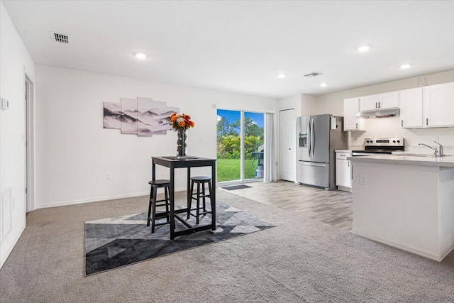 kitchen featuring wood-type flooring, white cabinetry, sink, and appliances with stainless steel finishes