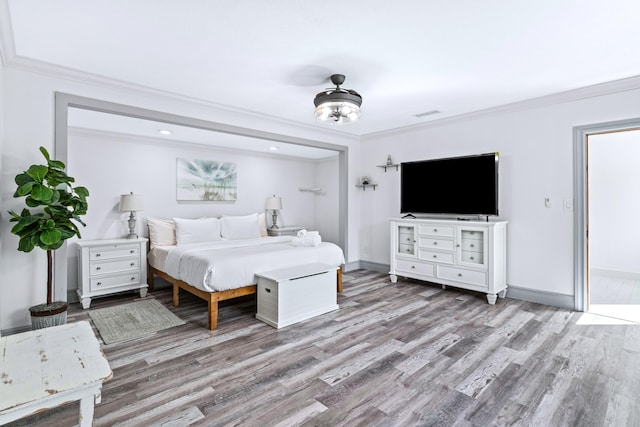 bedroom featuring hardwood / wood-style floors, ceiling fan, and ornamental molding