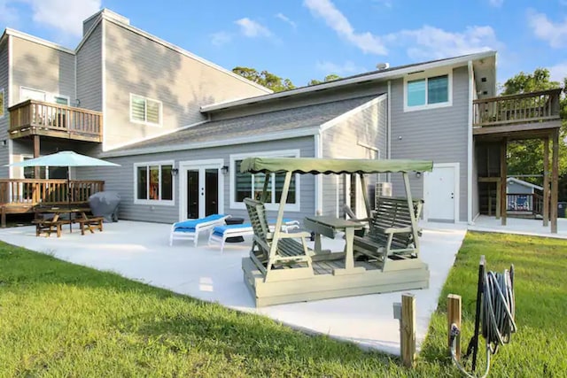 back of house featuring a patio, a yard, french doors, and a balcony