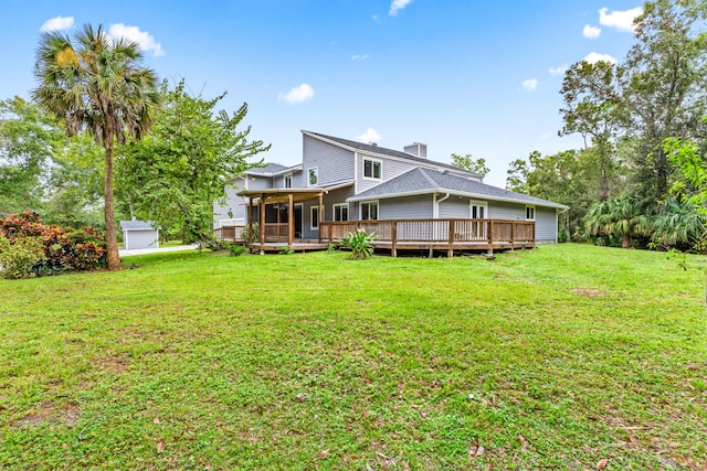 back of house with a wooden deck and a lawn