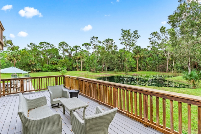 wooden deck featuring a water view and a lawn