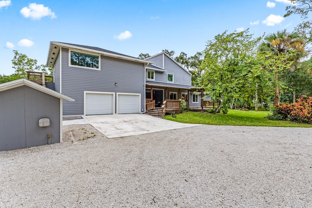 front of property featuring a front lawn, a garage, and covered porch