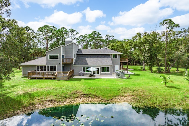 back of house featuring a deck with water view, a yard, and a patio