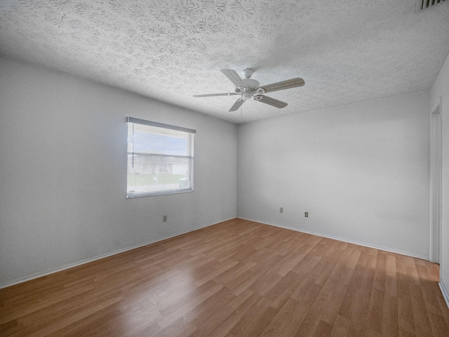 unfurnished room with ceiling fan, wood-type flooring, and a textured ceiling