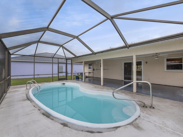 view of pool featuring glass enclosure, a patio, and ceiling fan