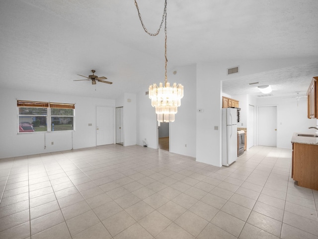 unfurnished room featuring ceiling fan with notable chandelier, vaulted ceiling, a textured ceiling, sink, and light tile patterned flooring