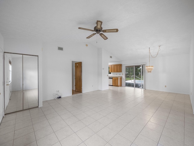 unfurnished living room featuring ceiling fan with notable chandelier, light tile patterned floors, and lofted ceiling