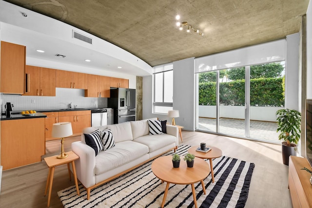 living area with visible vents and light wood-style floors