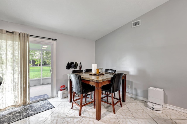 tiled dining area with lofted ceiling