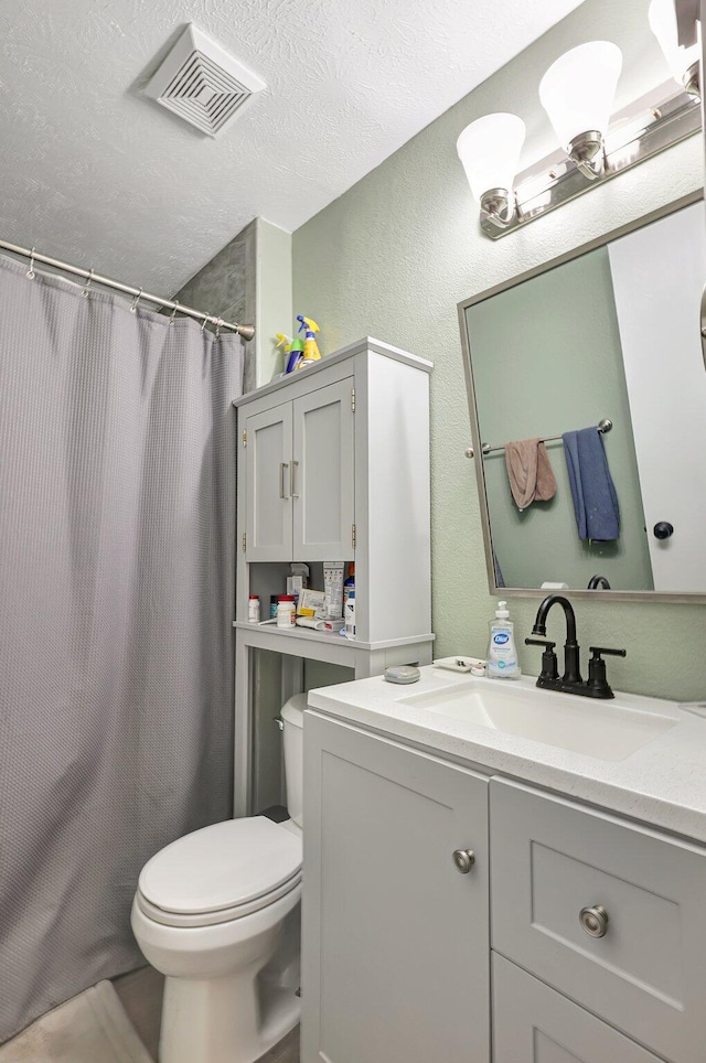 bathroom with walk in shower, vanity, toilet, and a textured ceiling