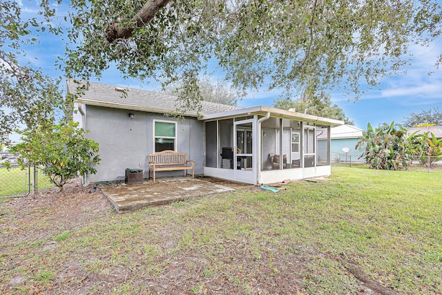 rear view of property featuring a lawn, a sunroom, and central AC