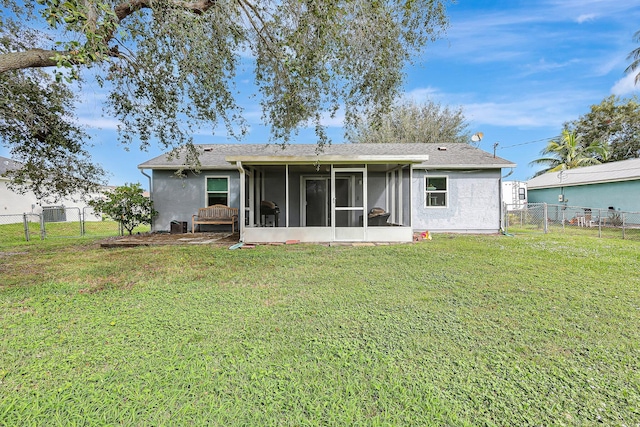 rear view of house with a sunroom and a yard