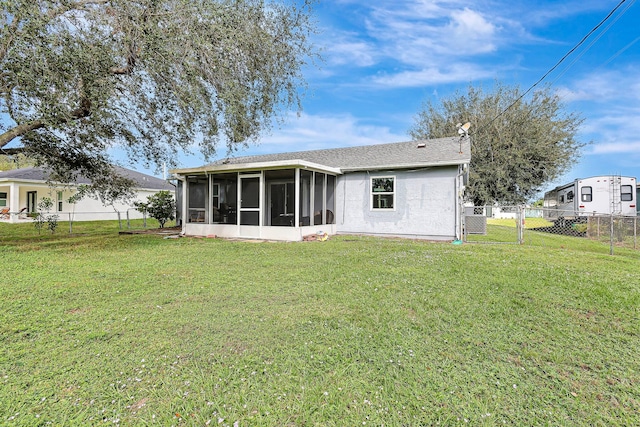 rear view of property with a sunroom and a lawn