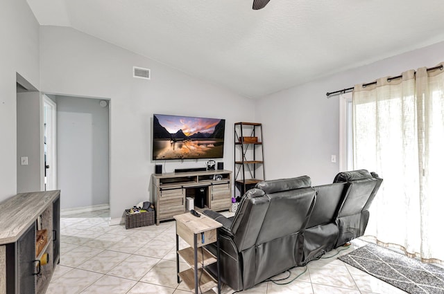 living room featuring lofted ceiling, a textured ceiling, and light tile patterned floors