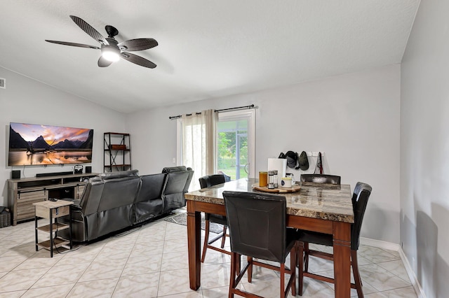 dining space with a textured ceiling, ceiling fan, vaulted ceiling, and light tile patterned floors