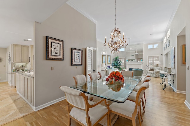 dining room featuring light hardwood / wood-style floors, an inviting chandelier, ornamental molding, and sink