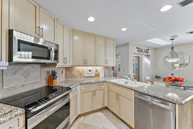 kitchen featuring sink, light tile patterned flooring, pendant lighting, appliances with stainless steel finishes, and kitchen peninsula