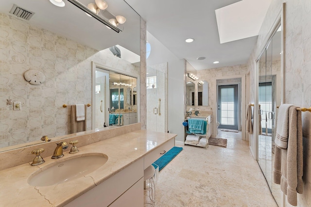 bathroom with vanity, a skylight, and an enclosed shower