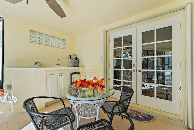 dining room with ceiling fan, french doors, a textured ceiling, and wet bar