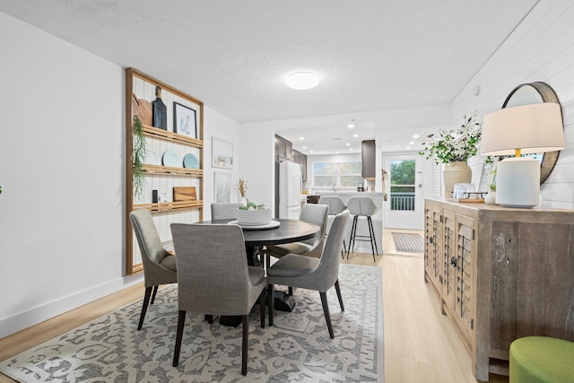 dining room with a textured ceiling and light hardwood / wood-style floors