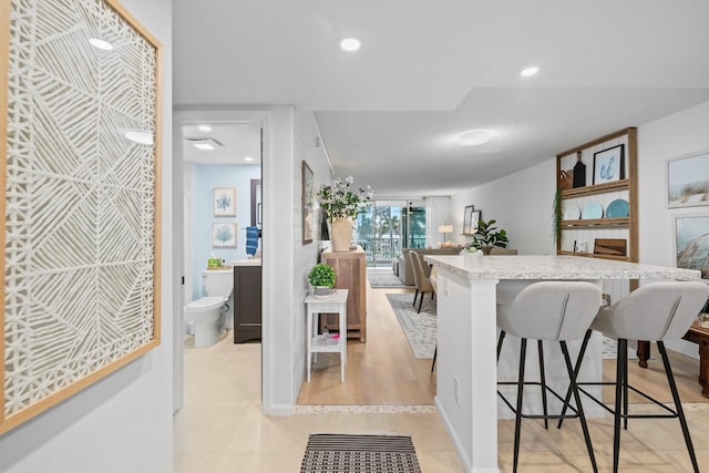 kitchen with light hardwood / wood-style floors and a kitchen bar