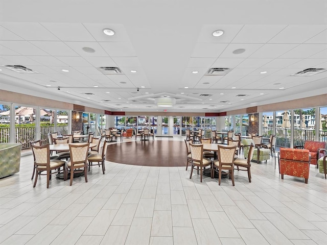 dining space with a drop ceiling and a healthy amount of sunlight