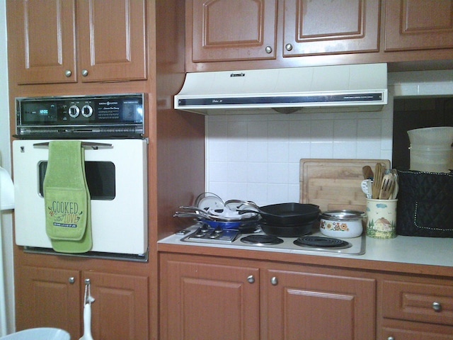 kitchen featuring white appliances and backsplash