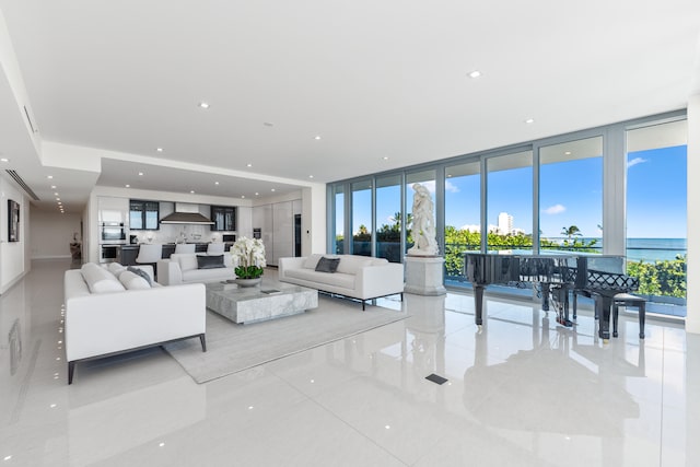 tiled living room featuring a wall of windows and a water view