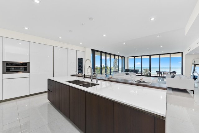 kitchen featuring white cabinets, dark brown cabinets, oven, and light tile patterned floors