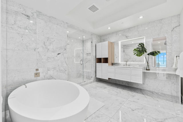 bathroom featuring vanity, tile walls, and separate shower and tub