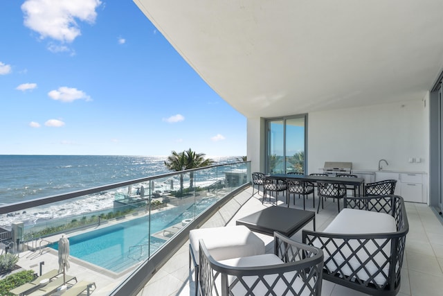 balcony featuring a view of the beach and a water view