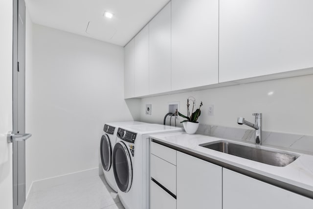 laundry room with washer and clothes dryer, cabinets, sink, and light tile patterned floors