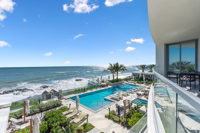 view of pool featuring a view of the beach, a water view, and a patio area