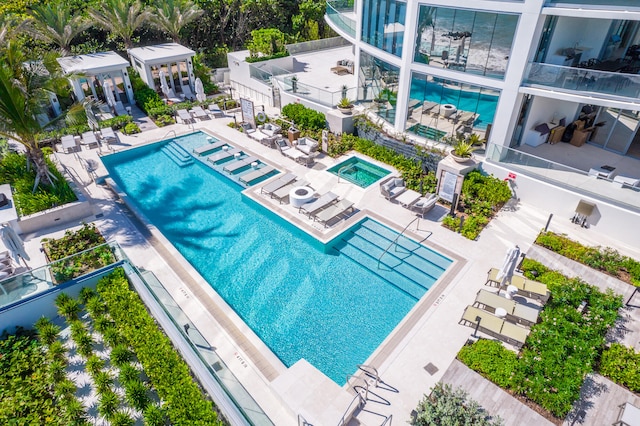 view of swimming pool featuring a hot tub and a patio area