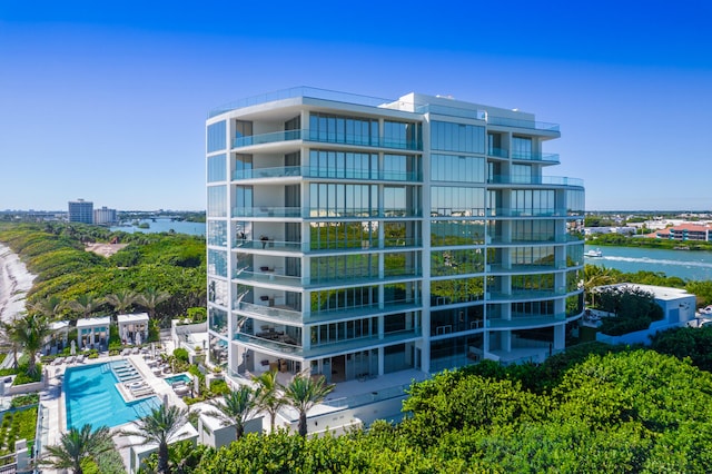 view of building exterior featuring a water view and a community pool