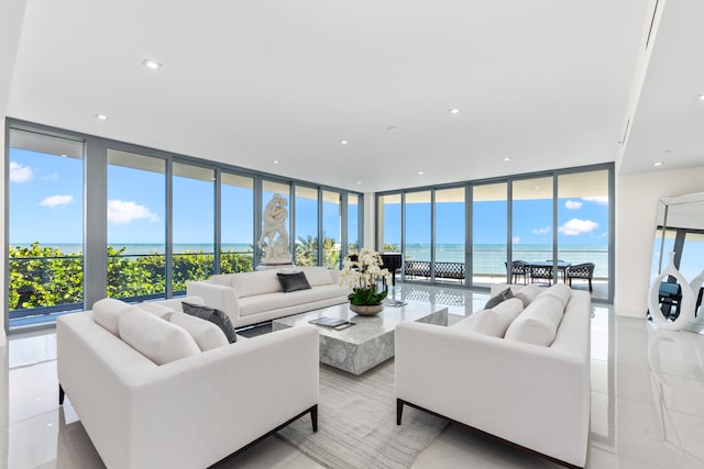 living room with plenty of natural light, a water view, and floor to ceiling windows