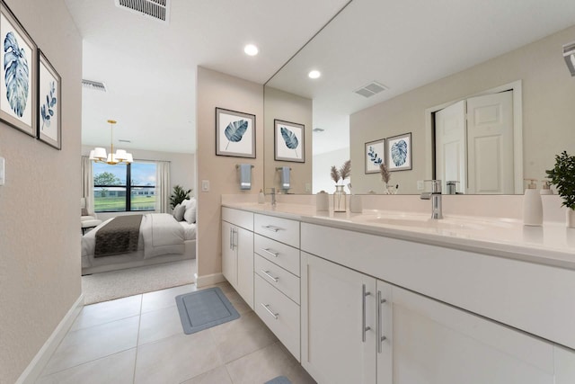 bathroom featuring tile patterned floors, vanity, and a notable chandelier