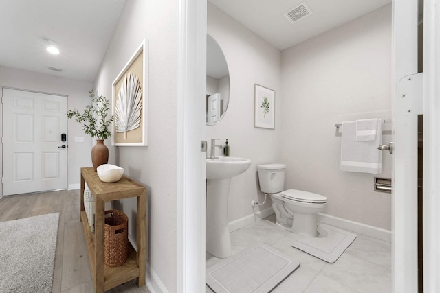 bathroom with toilet and hardwood / wood-style floors