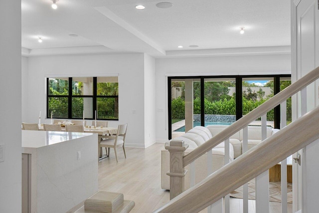 13450 Artisan Cir, Palm Beach Gardens, FL 33418 - hall with light wood-type flooring, baseboards, a tray ceiling, and recessed lighting
