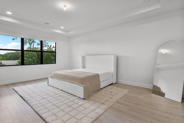 13450 Artisan Cir, Palm Beach Gardens, FL 33418 - bedroom featuring a tray ceiling, light wood-type flooring, recessed lighting, and baseboards