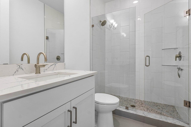 bathroom featuring a stall shower, vanity, and toilet