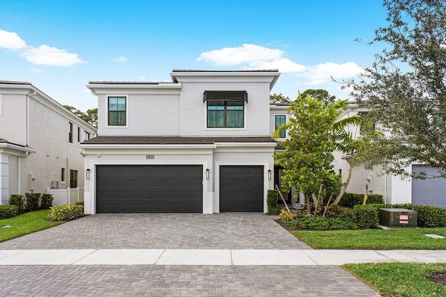 13450 Artisan Cir, Palm Beach Gardens, FL 33418 - view of front facade featuring an attached garage, decorative driveway, and stucco siding