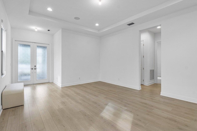 13450 Artisan Cir, Palm Beach Gardens, FL 33418 - unfurnished room with a raised ceiling, french doors, light wood-style floors, and recessed lighting