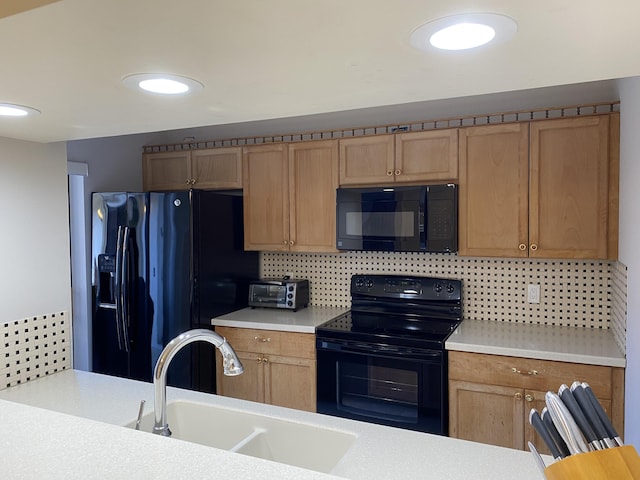 kitchen featuring decorative backsplash, sink, and black appliances