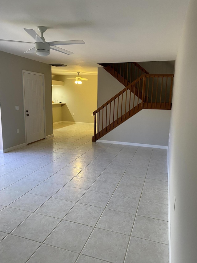 tiled empty room featuring ceiling fan