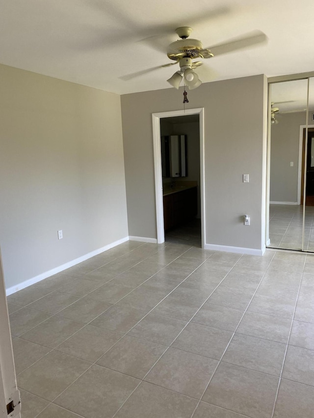 tiled empty room featuring ceiling fan