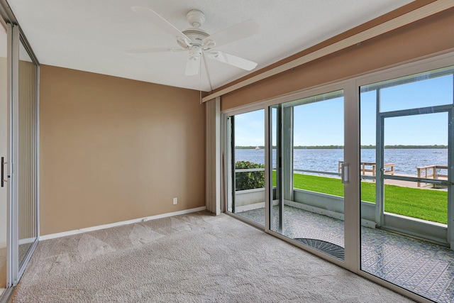 60 Yacht Club Dr Unit 106, North Palm Beach, FL 33408 - carpeted empty room featuring a water view, ceiling fan, and baseboards